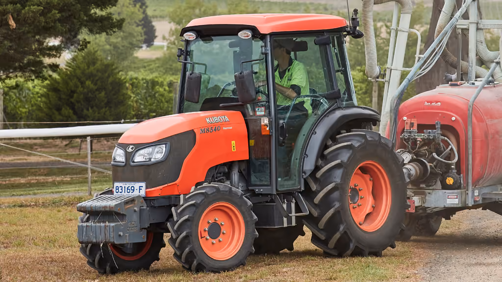 Orange Kubota tractor with roll-over protection.