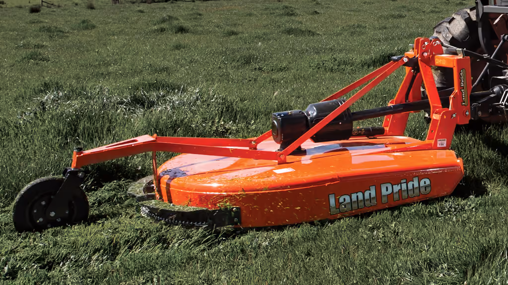 Orange rotary cutter attachment for pasture and field mowing.