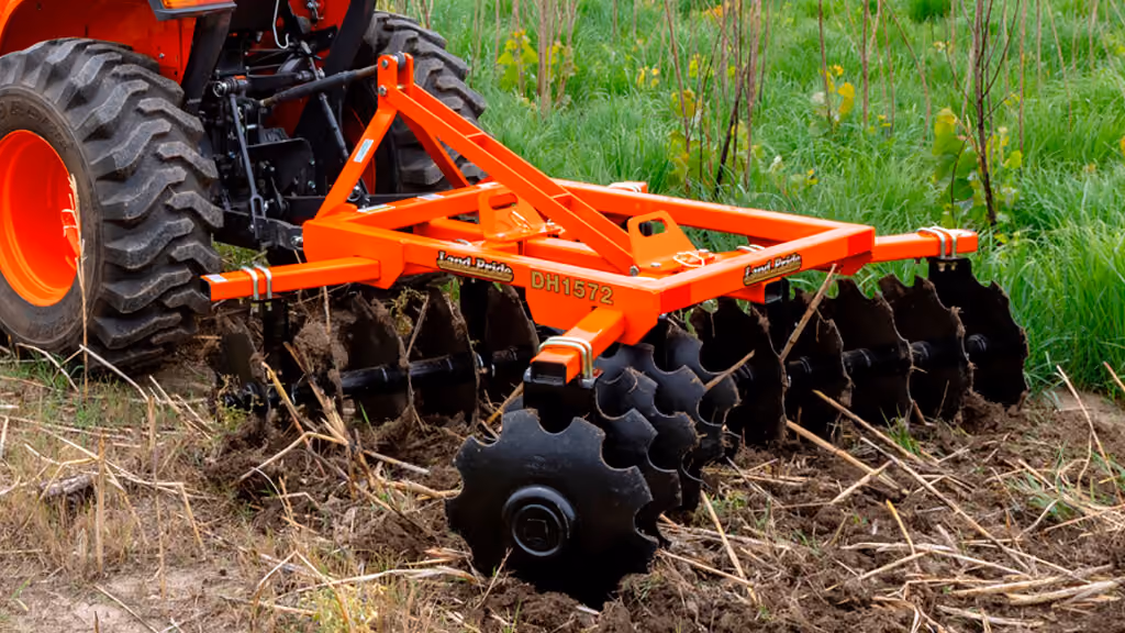 Orange disc harrow attachment with angled steel discs.