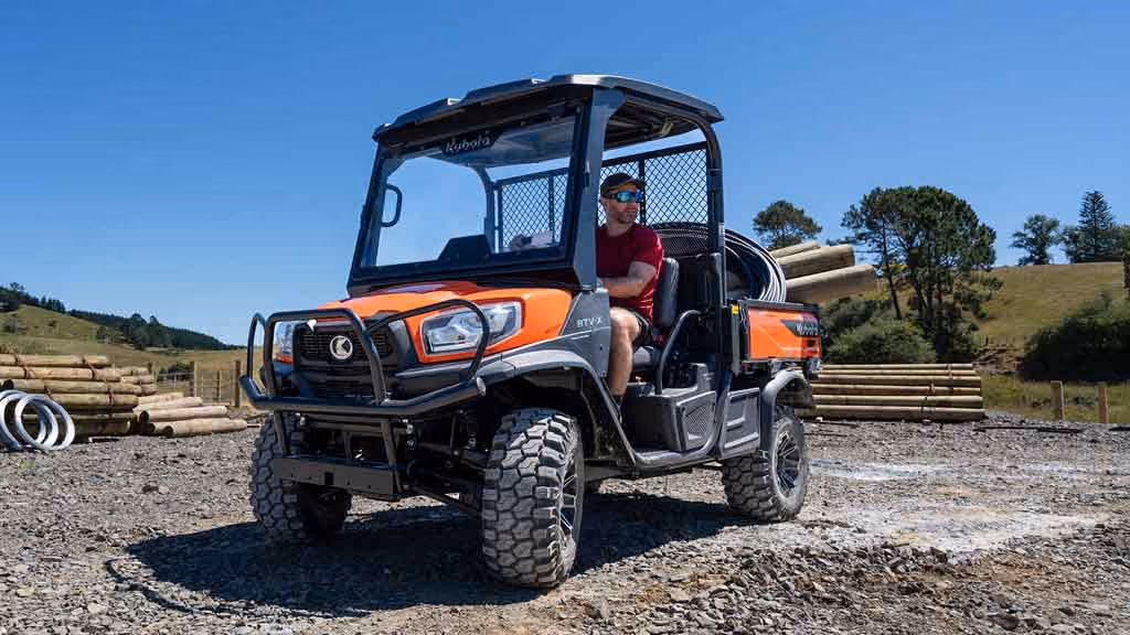 Orange Kubota utility vehicle with open cargo tray.