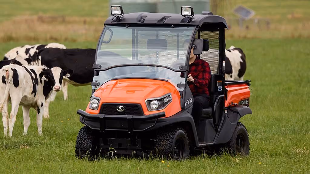 Orange Kubota utility vehicle with open cargo tray.