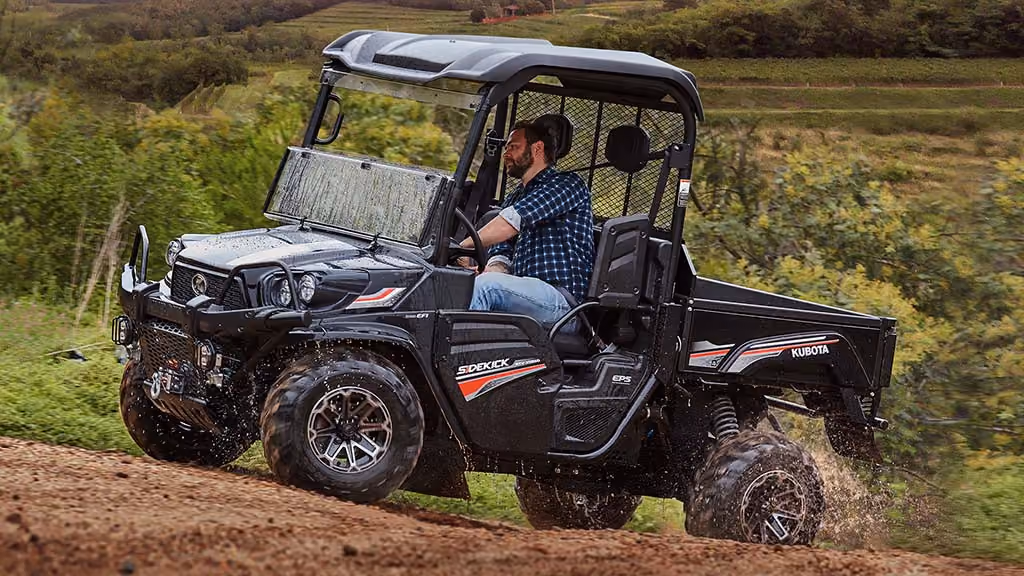 Orange Kubota utility vehicle with open cargo tray.