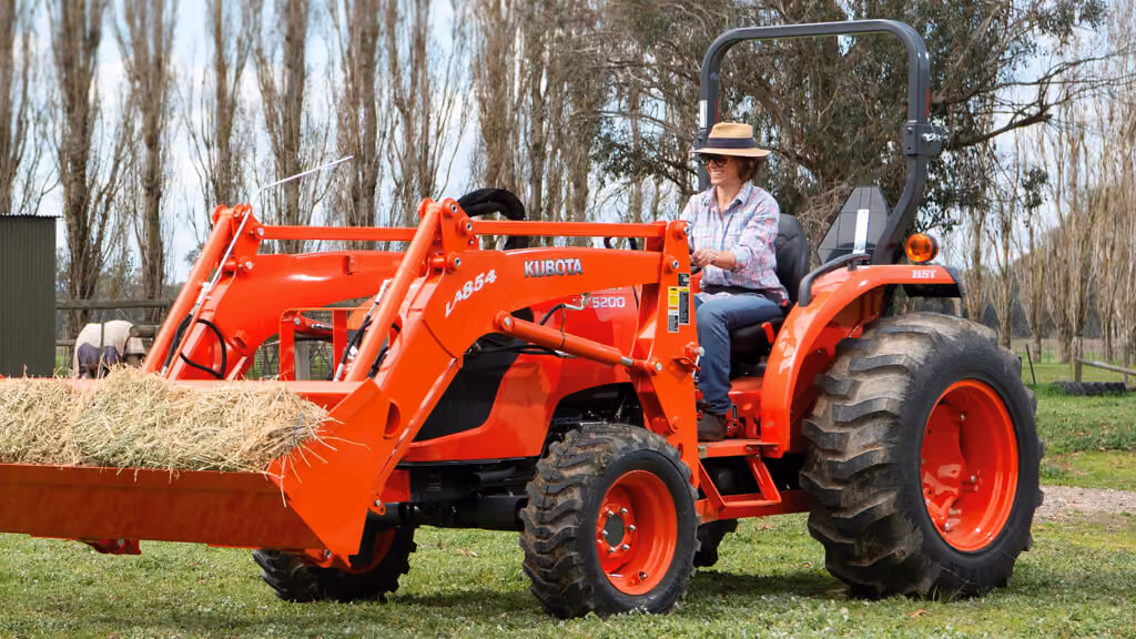 Orange Kubota tractor with roll-over protection.