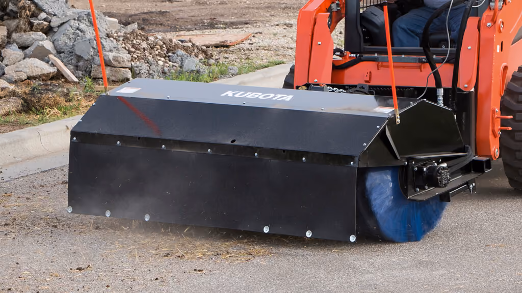 Rotary broom attachment with wide cylindrical brush.
