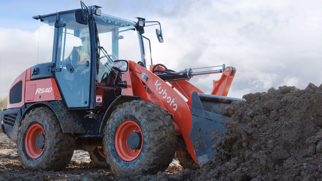 Orange Kubota wheel loader with front bucket.