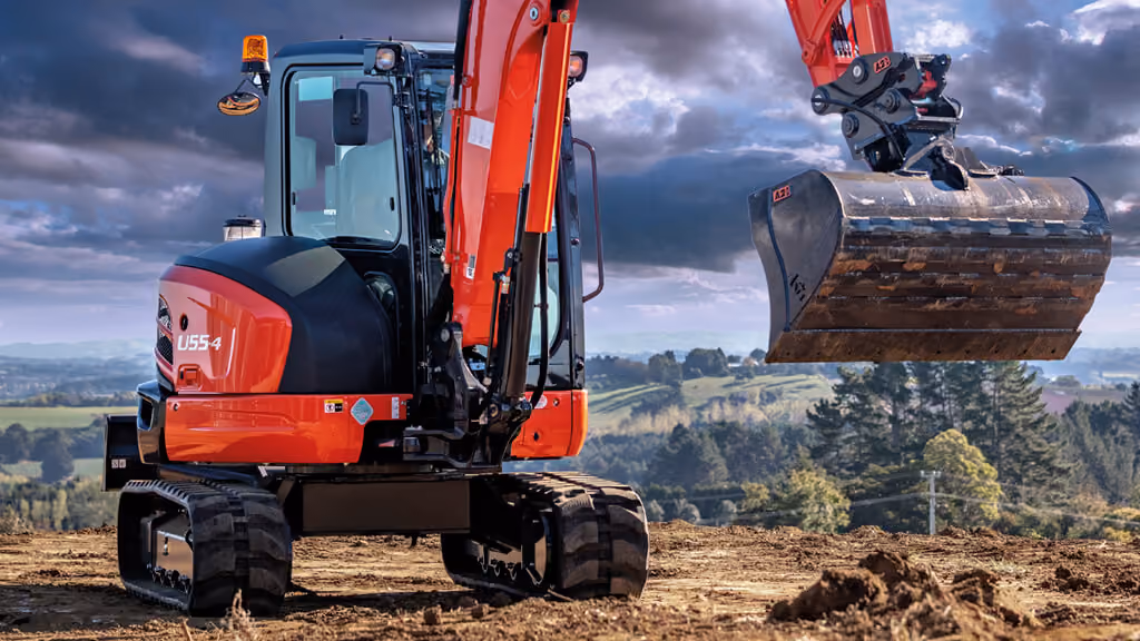 Orange Kubota excavator with tracked undercarriage and digging arm.
