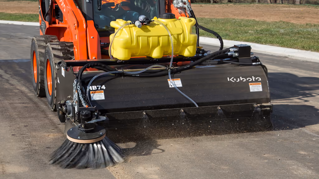 Rotary broom attachment with wide cylindrical brush.