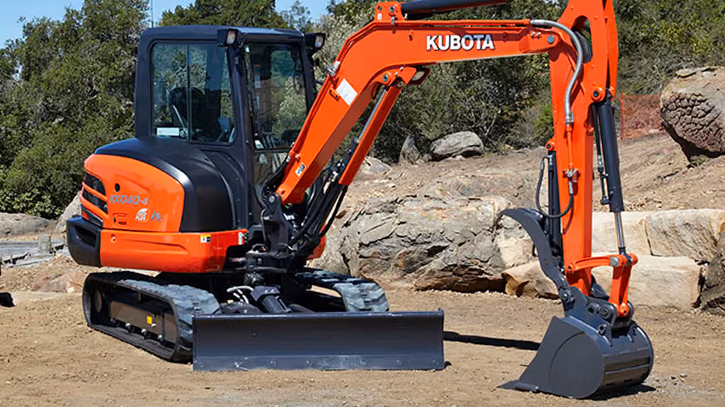 Orange Kubota excavator with tracked undercarriage and digging arm.