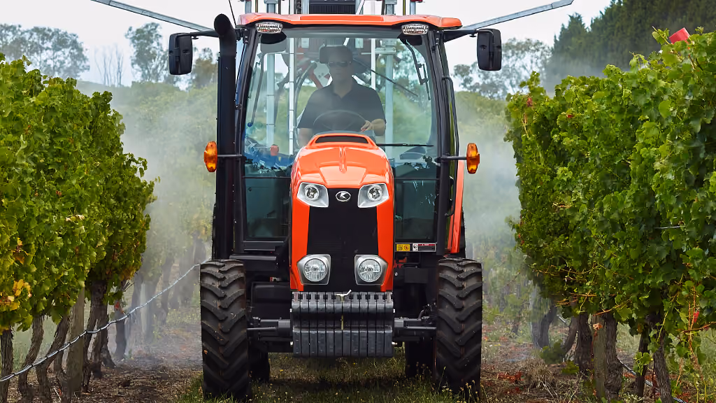 Orange Kubota tractor with roll-over protection.