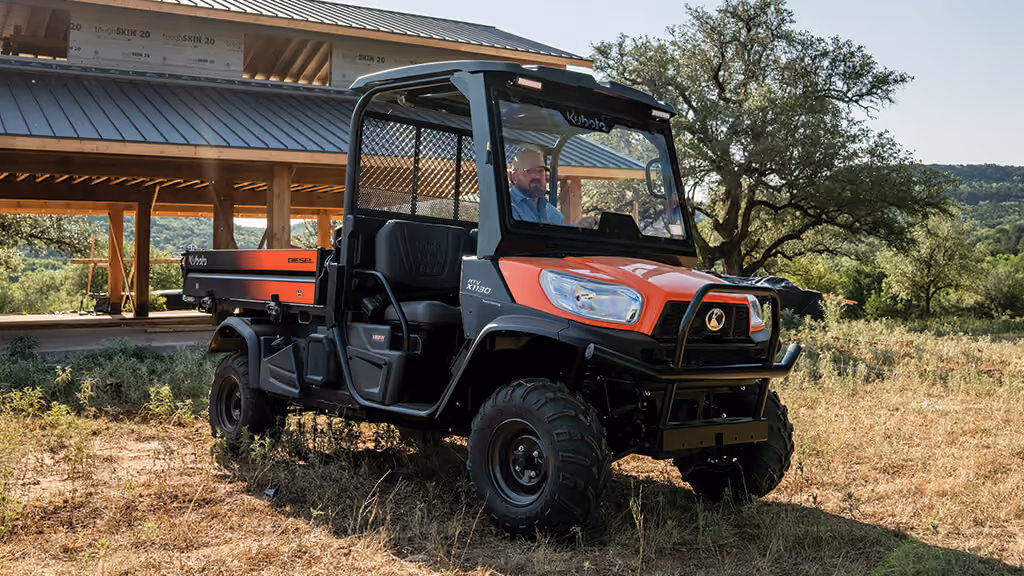 Orange Kubota utility vehicle with open cargo tray.