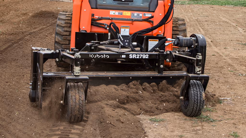 Orange rake attachment with rows of steel tines.