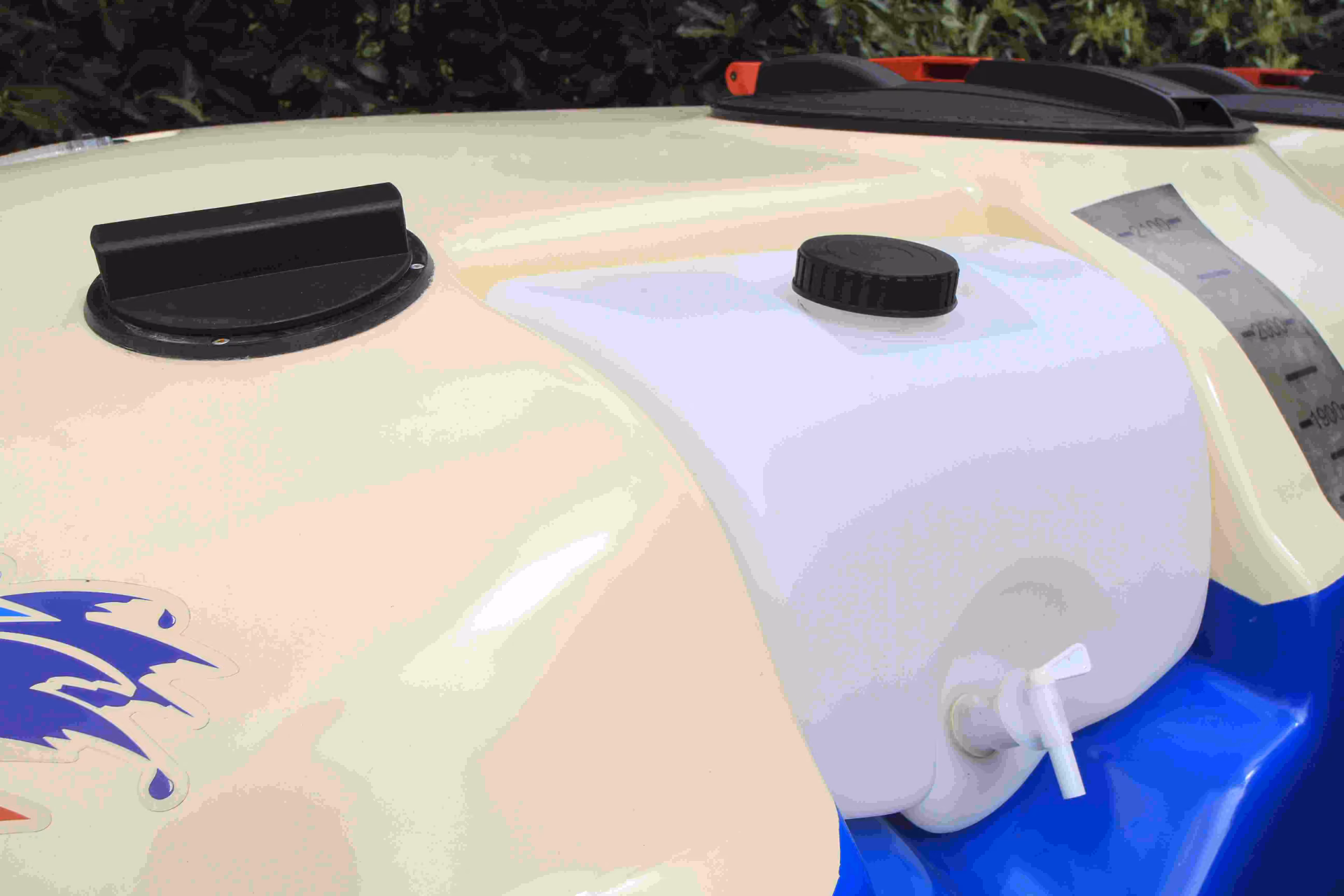 Hand-wash tank and black filler cap set into the top of the sprayer's cream fibreglass tank.