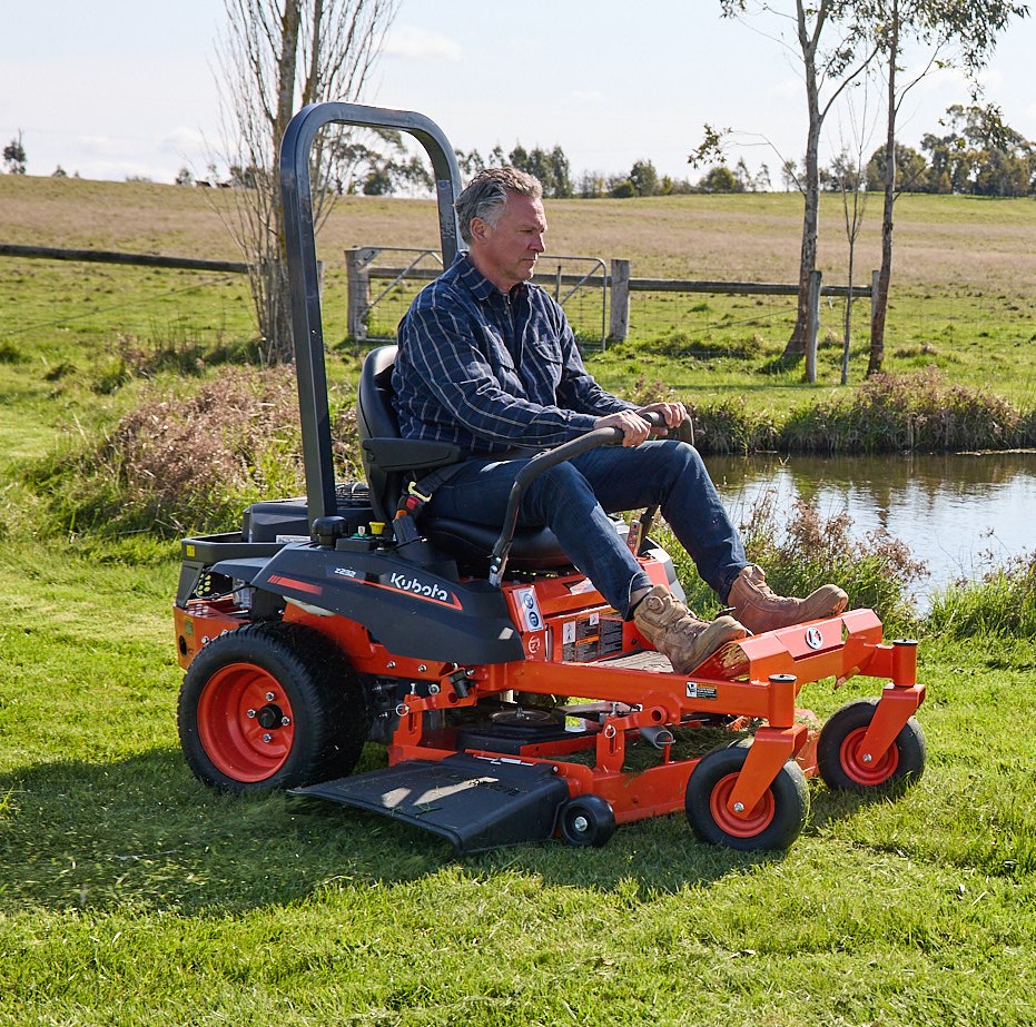 Orange Kubota mower with cutting deck.