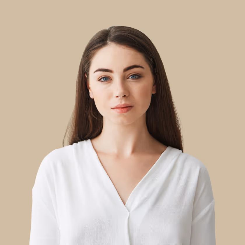 Portrait of a woman with long brown hair and blue eyes wearing a white V-neck top.