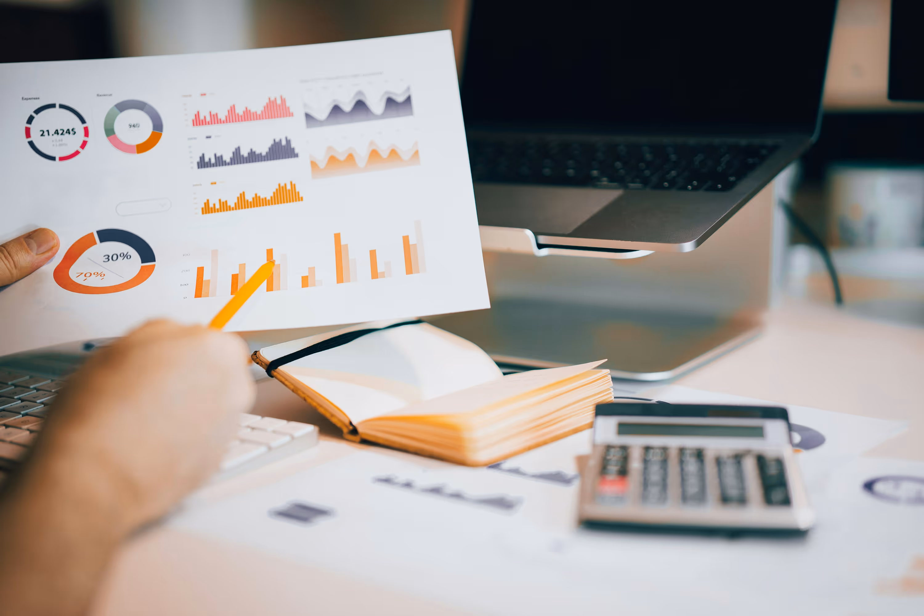 Laptop on table displaying a dashboard with charts and data analytics in a modern workspace.