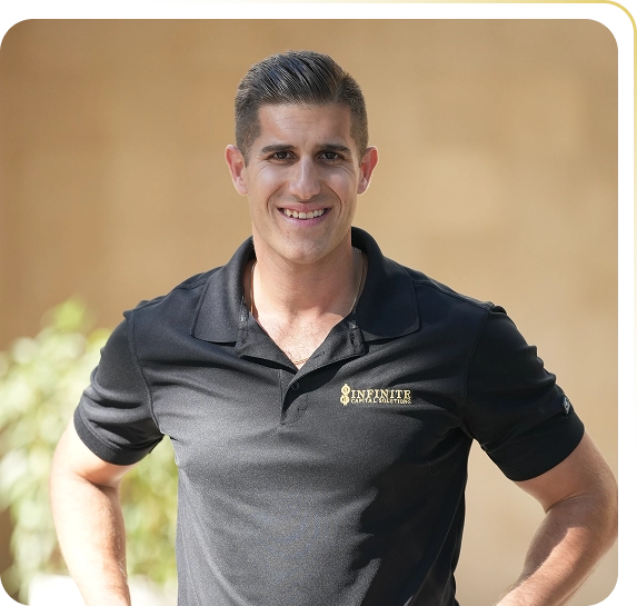 Smiling man wearing a black polo shirt with Infinite Capital Solutions logo standing outdoors.