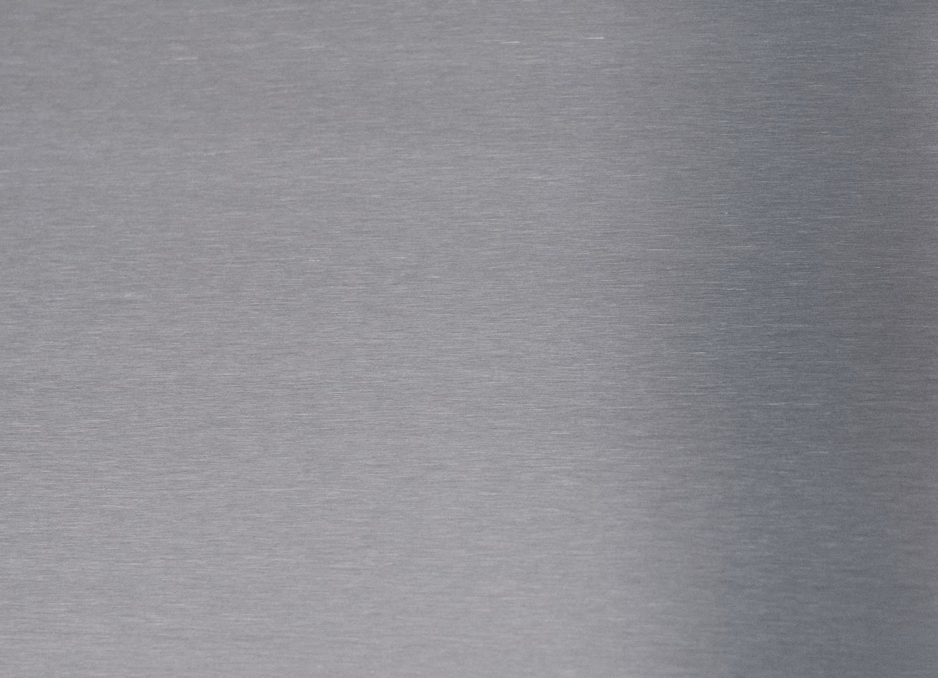 Glatte Oberfläche aus gebürstetem Edelstahl mit feiner Textur.