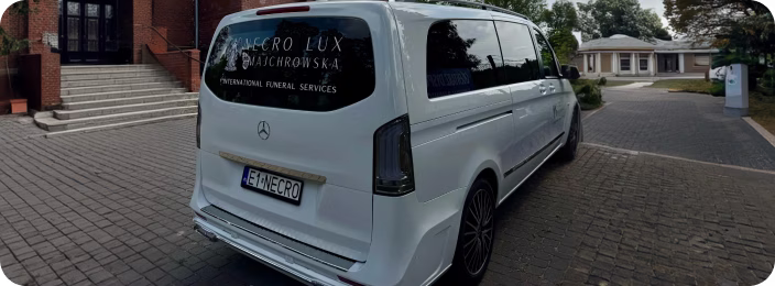 Білий лімузин Mercedes-Benz із написом міжнародних послуг похорон Necro Lux на задньому вікні.