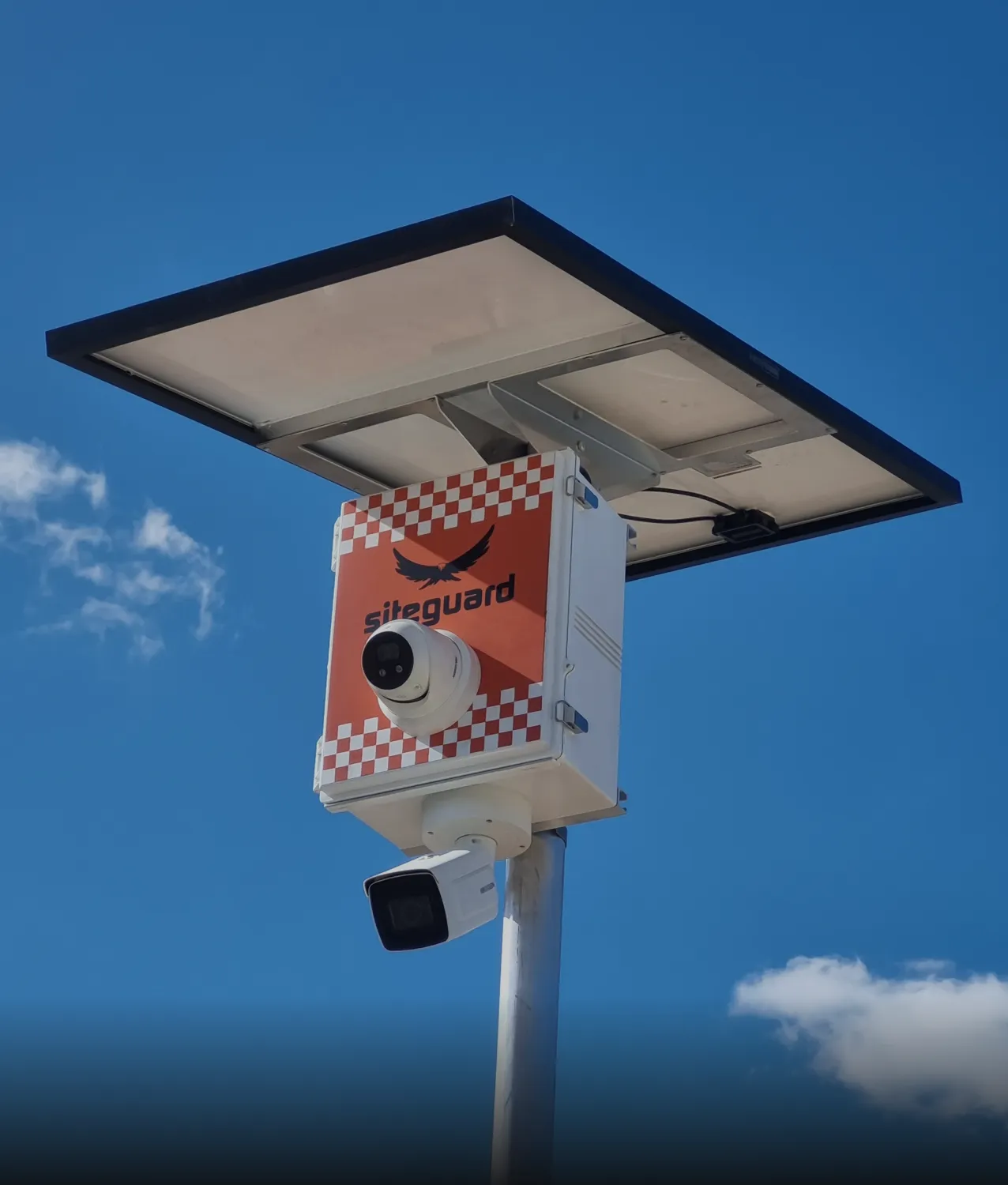 Siteguard camera unit with a dome camera and a bullet camera under a solar panel on a pole