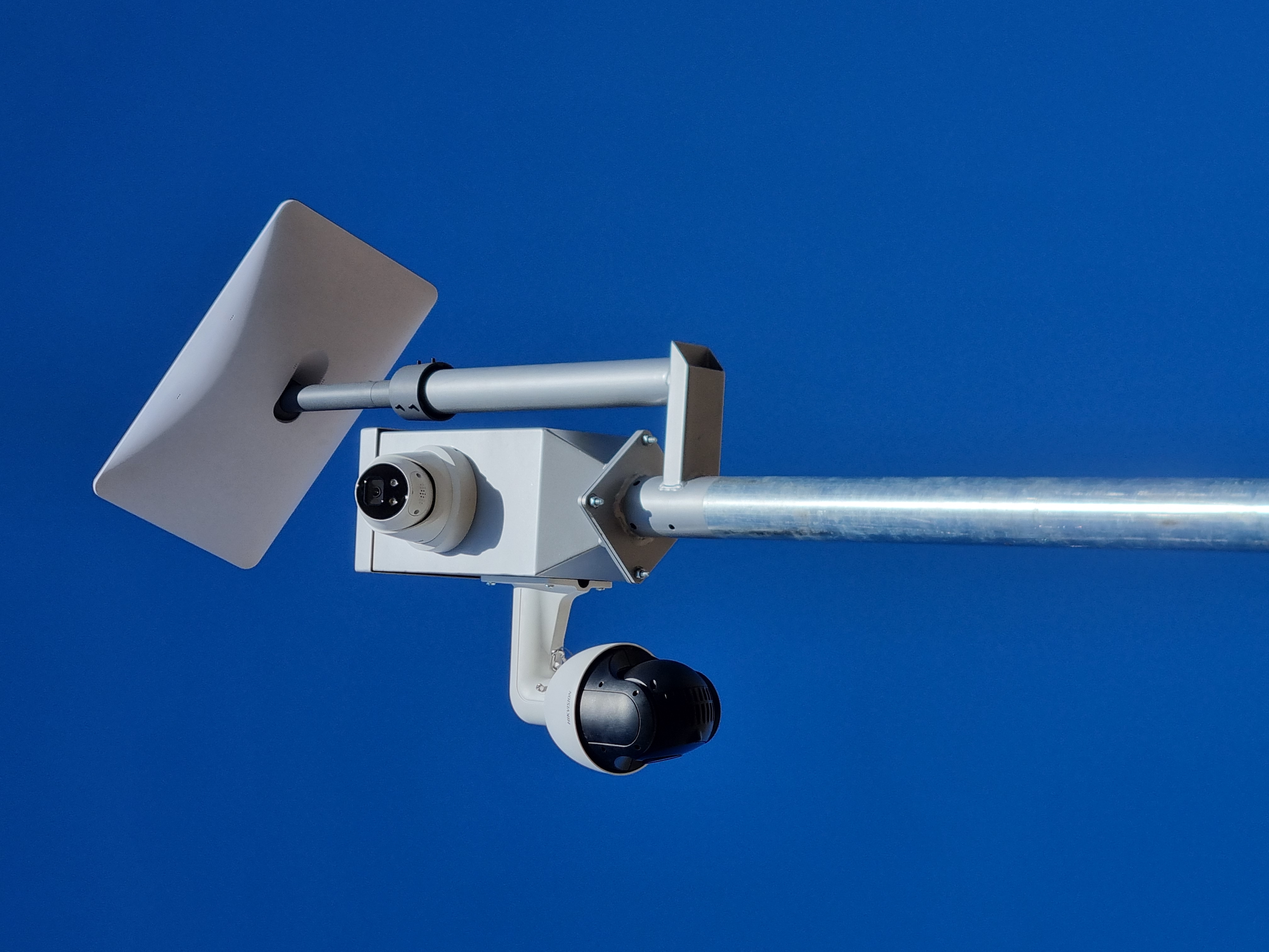 Starlink dish mounted with a dome camera and a pan-tilt-zoom camera on a galvanised pole