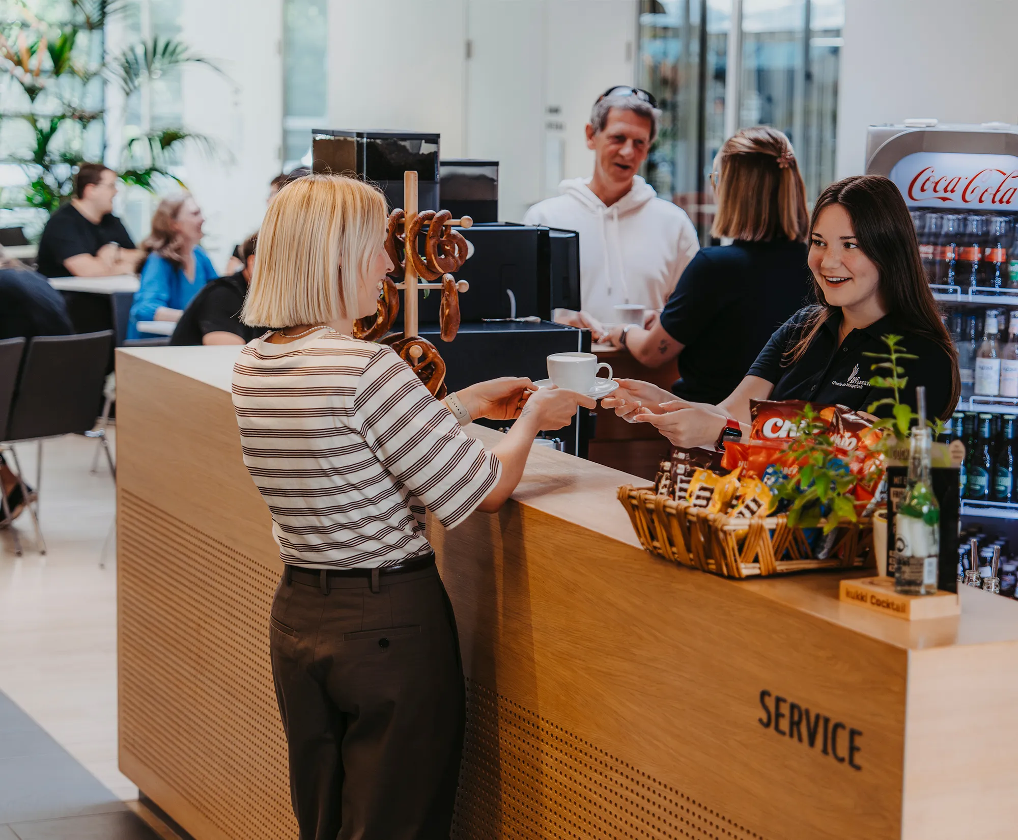Freundlicher Service und Übergabe von Kaffeespezialitäten am modernen Tresen im Café des Kurhauses Bad Bevensen.