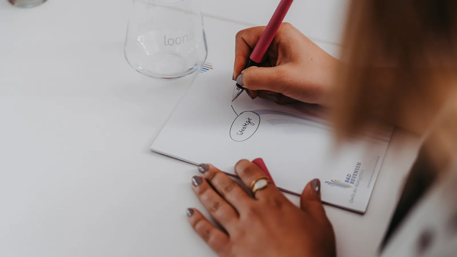 Konzentriertes Arbeiten und Notieren von Ideen während eines produktiven Seminars im professionell ausgestatteten Raum Betula.