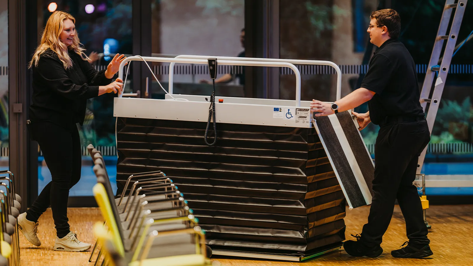 Veranstaltungstechniker beim reibungslosen Aufbau der flexiblen Konzertbestuhlung für ein anstehendes Großevent im barrierefreien Kursaal des Kurhauses.