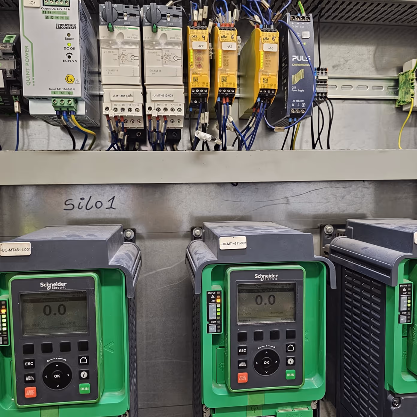 Industrial electrical panel with Schneider Electric controls, relays, and wiring labeled 'silo1'.