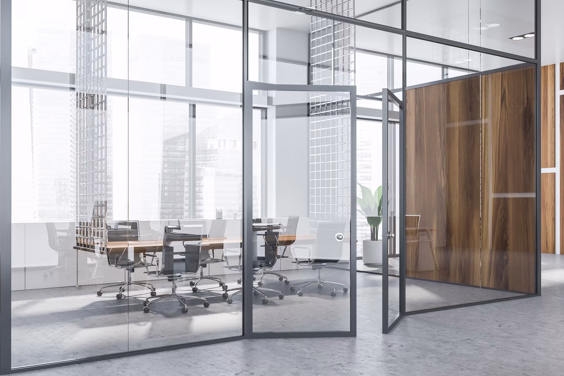 Moderner Konferenzraum mit Glastrennwänden, grauen Bürostühlen und Holztisch.