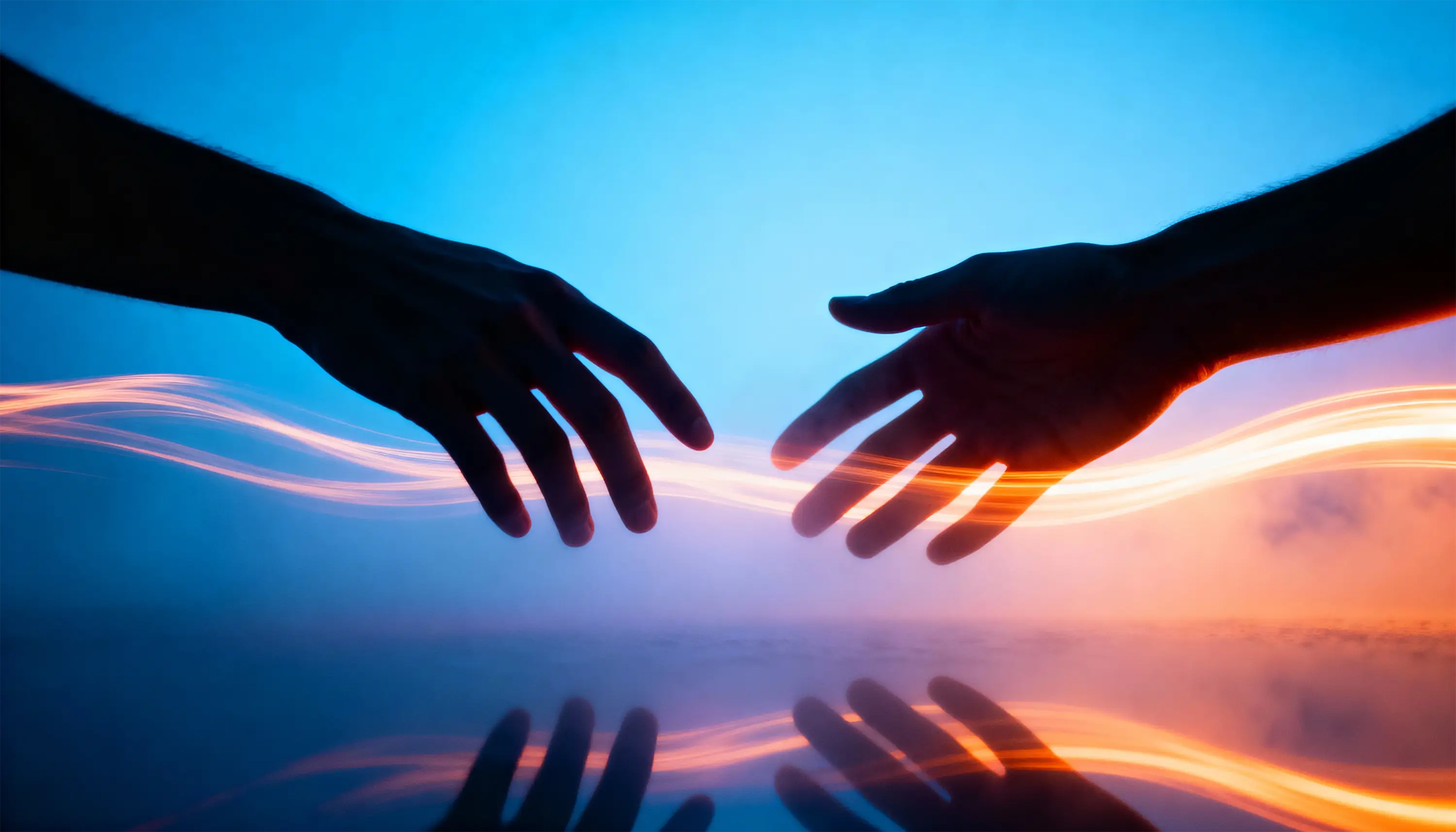 Silhouetten von zwei Händen mit leuchtender Verbindung als Symbol für Kontaktaufnahme, Austausch und den Start eines neuen Website-Projekts.