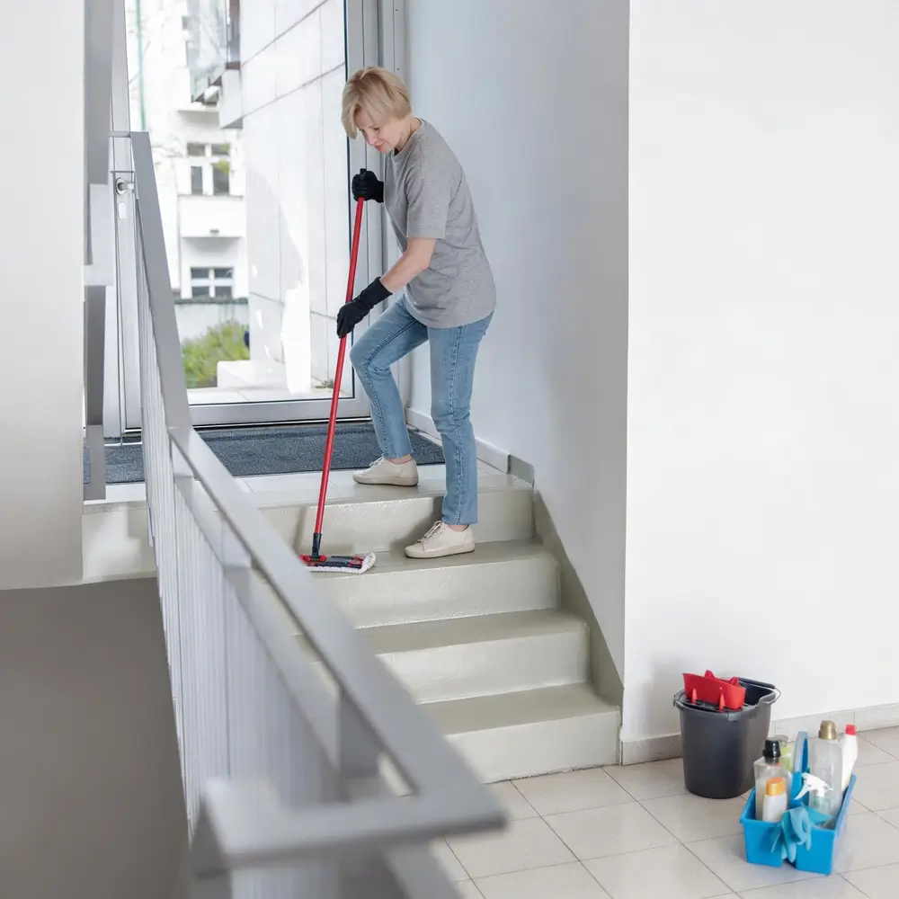 A OK Cleaning team member mopping stairwell steps in a Sydney strata building common area