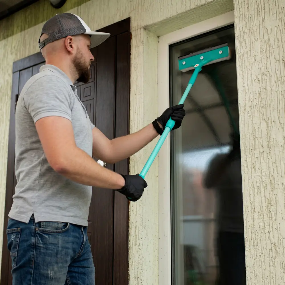 A OK Cleaning team member cleaning exterior windows of a residential home in Sydney