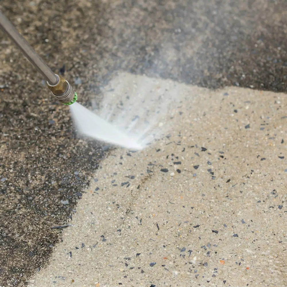 Close up of high pressure water jet cleaning a dirty concrete surface in Sydney showing before and after result