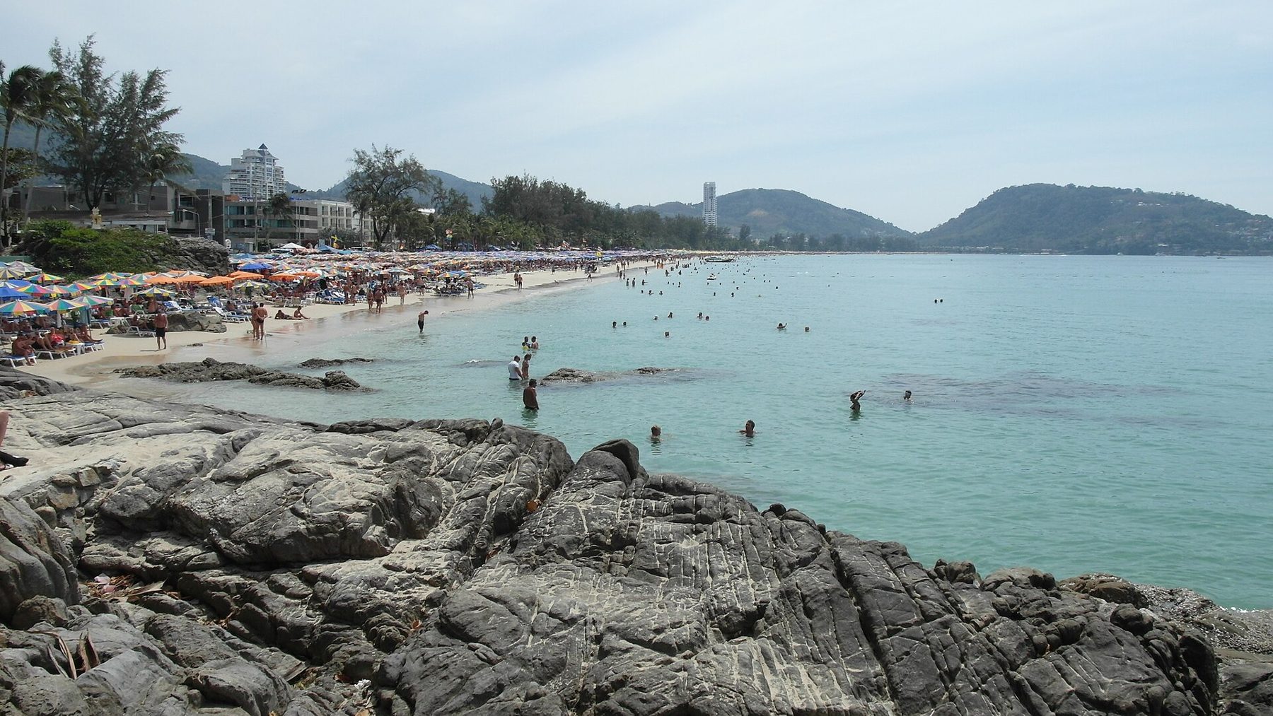 Rocky coastline and beach in Phuket with villas on the hillside
