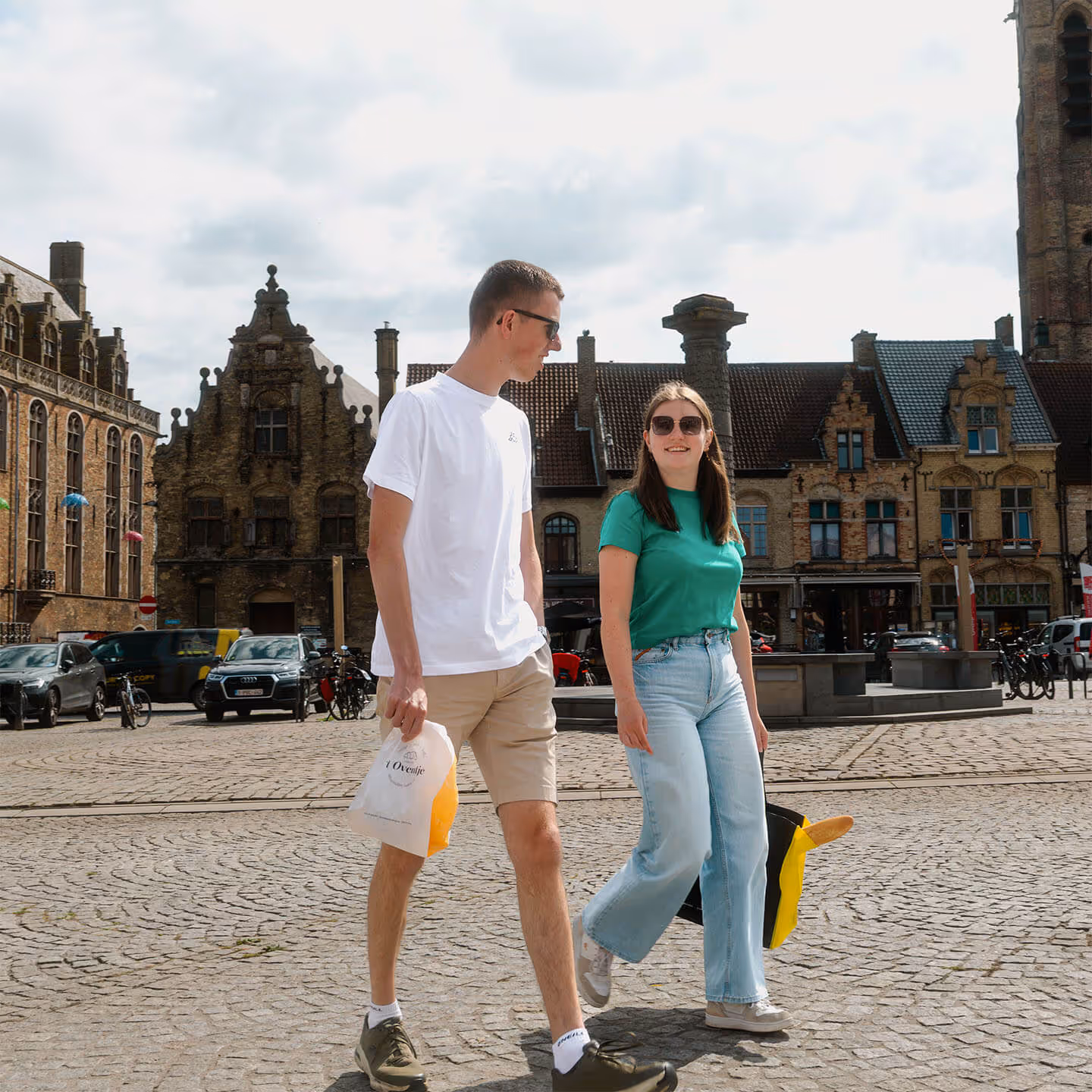 Wandelen op de markt van Veurne met een zakje en draagtas van bakkerij 't Oventje.