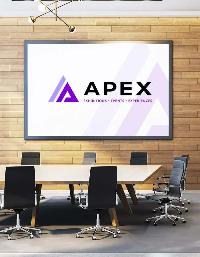 Modern conference room with wooden walls, white table, black chairs, and a screen displaying APEX logo.