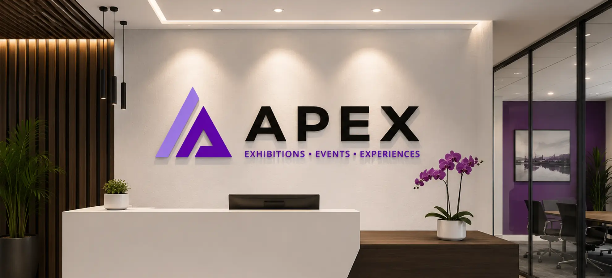 Modern reception area with white desk, purple orchids, and Apex logo on wall with text Exhibitions Events Experiences.