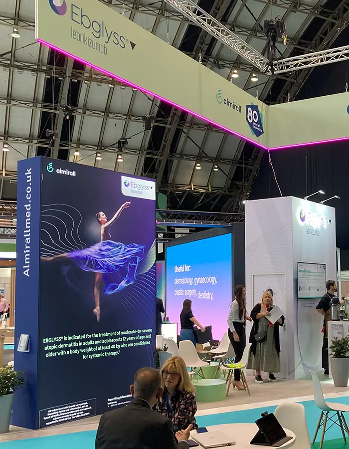 Trade show booth for Ebglyss by Almirall with a dancer image and information on dermatology uses.