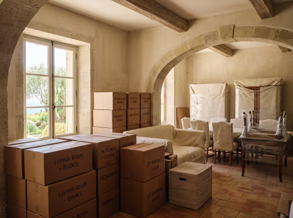 Meubles soigneusement emballés et cartons empilés dans un espace de stockage temporaire lumineux lors d'une transition de logement à Saint-Raphaël.