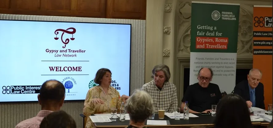 An event in which people are speaking in front of a screen which reads "Gypsy and TRaveller Law Network: Welcome"