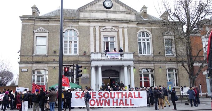 A crowd outside Southall Town Hall holding a 'Save Southall Town Hall' banner