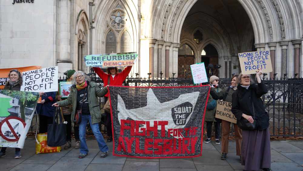 Campaigners outside the Royal Courts of Justice holding a 'Refurbish Don't Demolish' banner