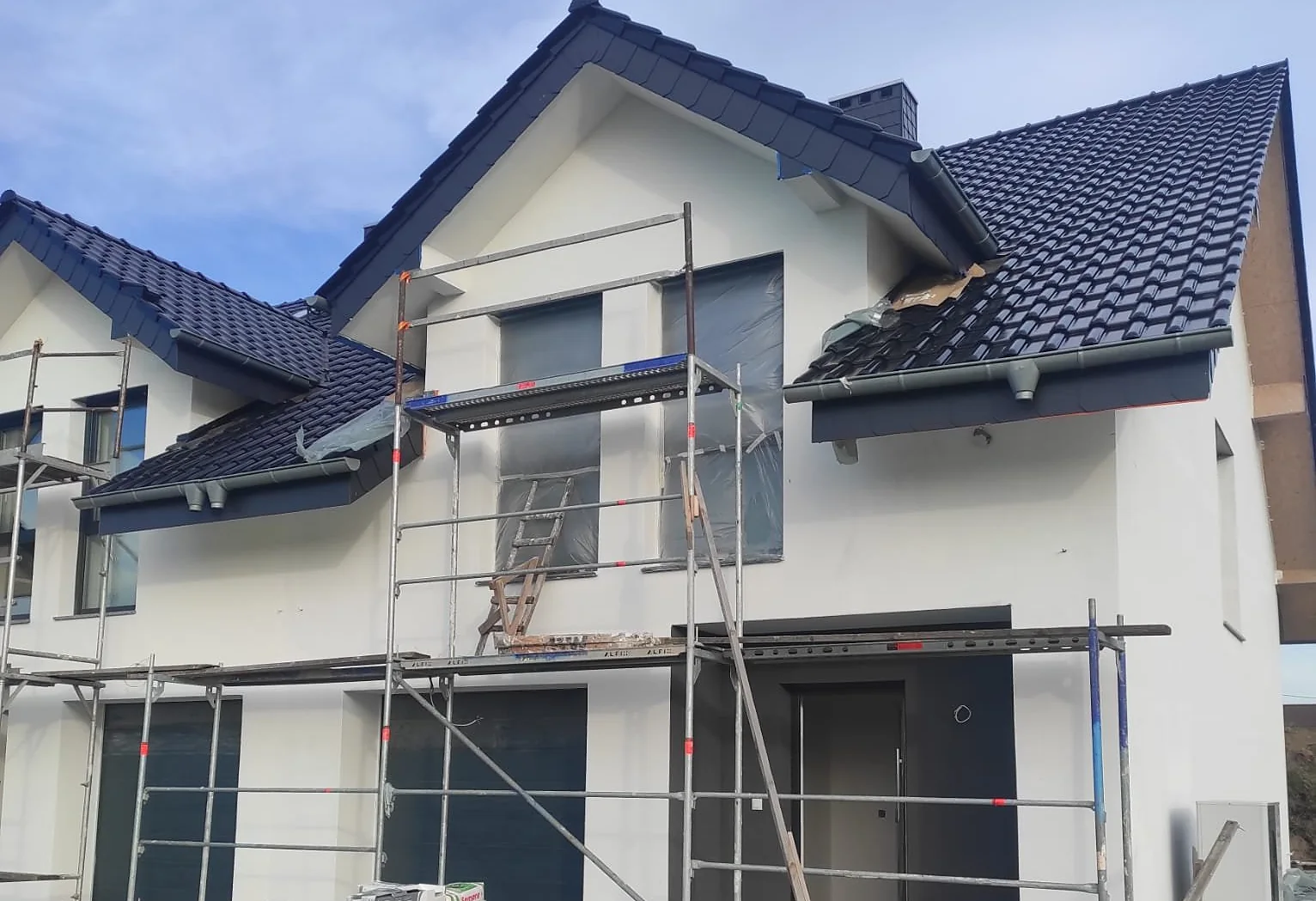 Renovation Expert house construction in progress with scaffolding.
