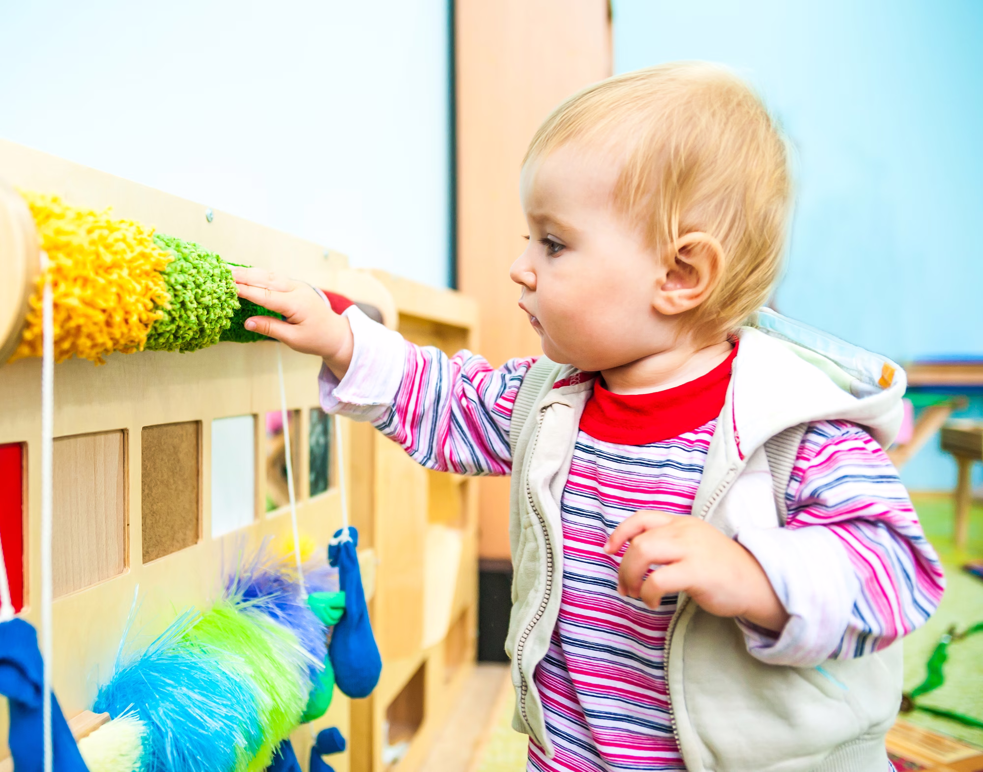Toddler exploring a colourful educational toy