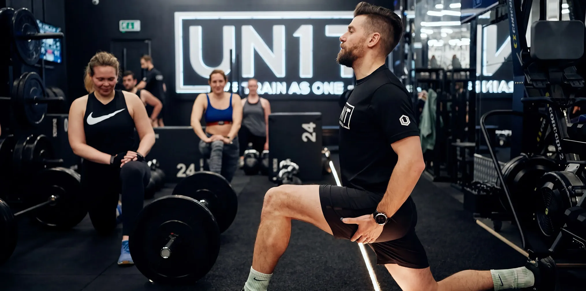 Male trainer coaching man lifting barbell in gym in two side-by-side images.