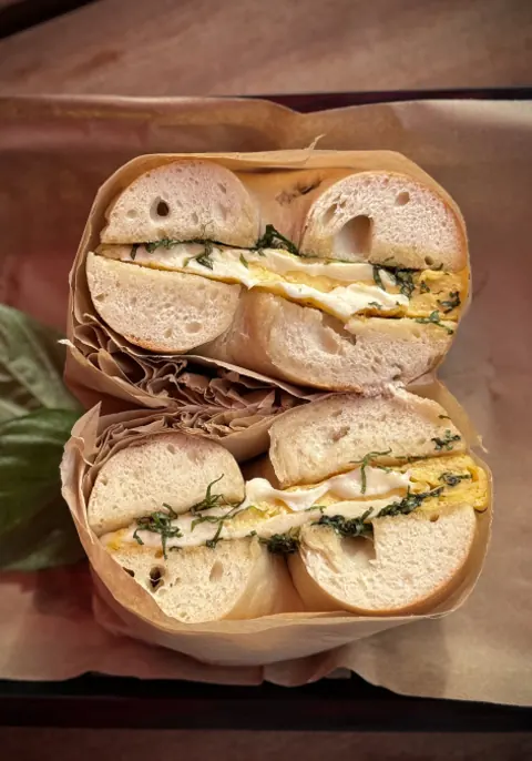 Bagel sandwich cut in half and wrapped in paper