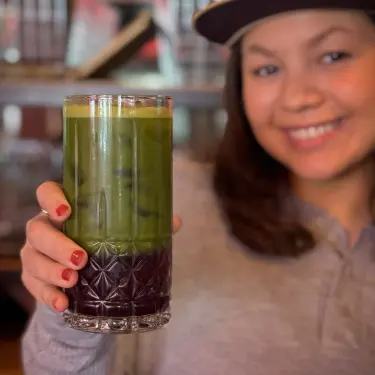 Person holding a glass of iced matcha