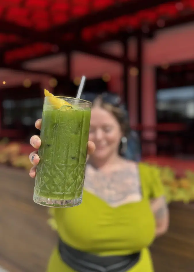 Person holding a matcha drink outside of Sunbeam