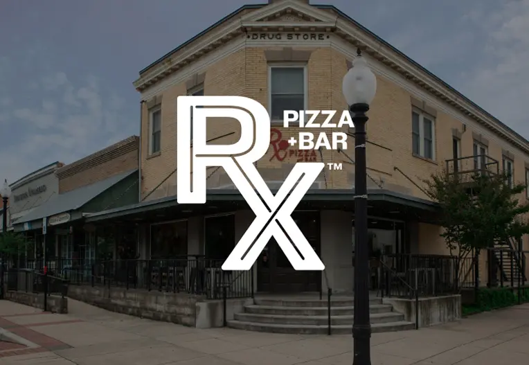 The outside of Rx Pizza during the day with the Rx Pizza + Bar logo over it