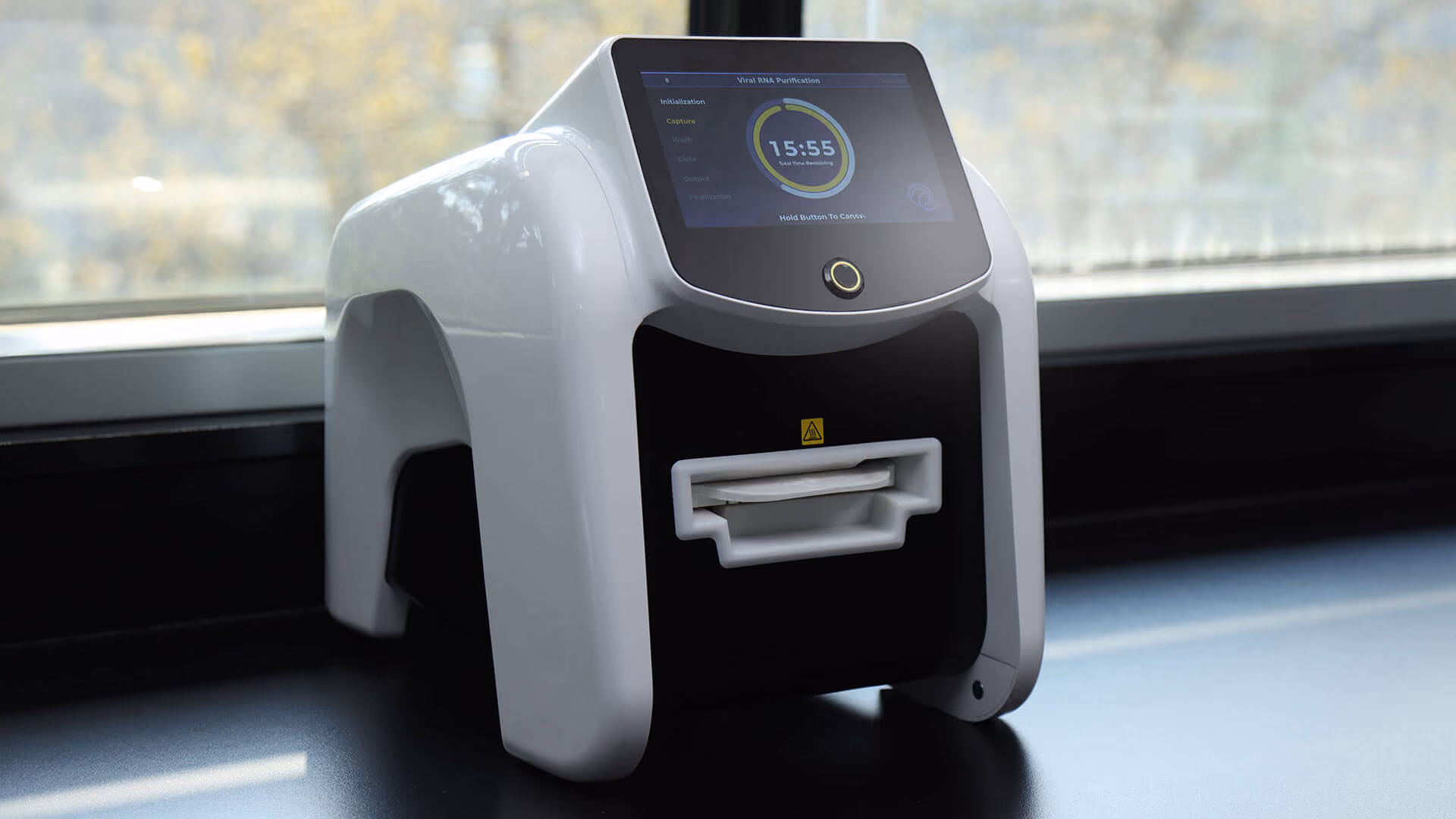 Laboratory device on black counter with digital touchscreen showing RNA purification progress.